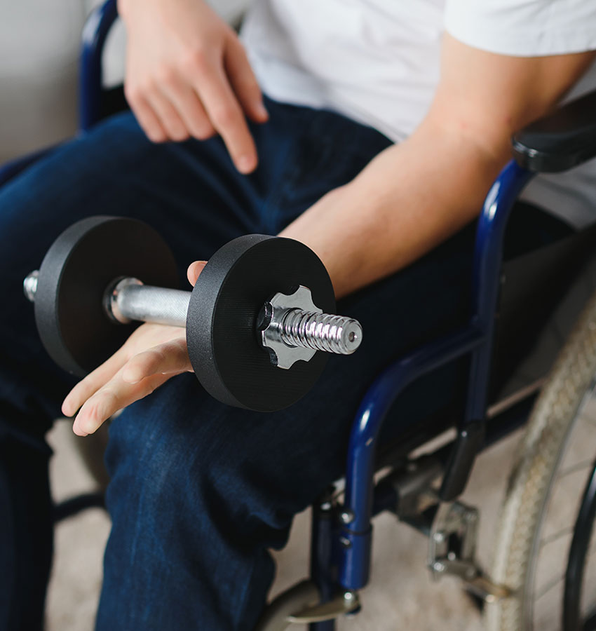 A seated member lifting a dumbbell during an adapted personal training session