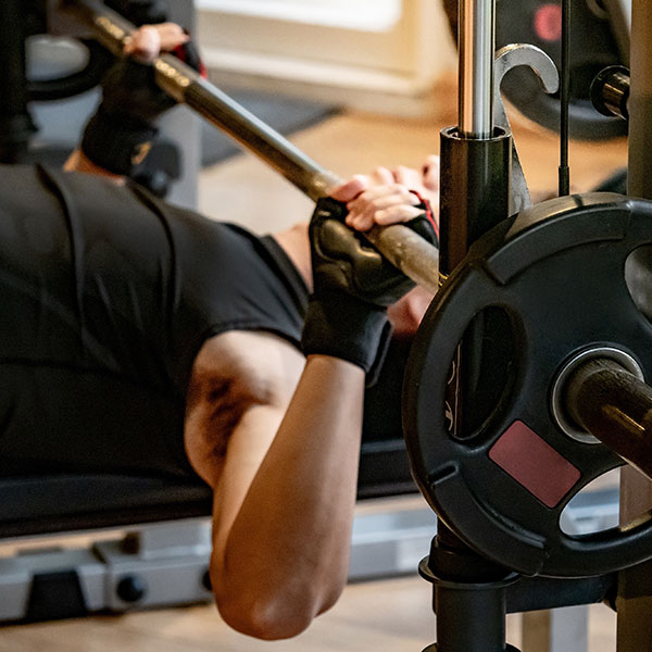 A member pressing a barbell during a group training session at Wallace Fitness Center