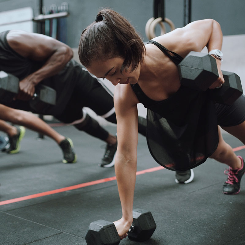 A group training class performing dumbbell rows at Wallace Fitness Center