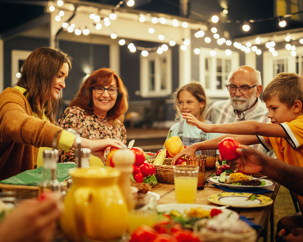 A family sharing a meal together at an outdoor table