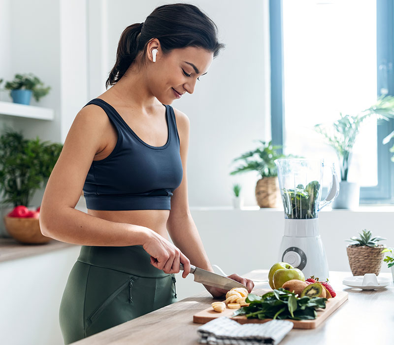 A woman preparing fresh fruit and vegetables in her kitchen